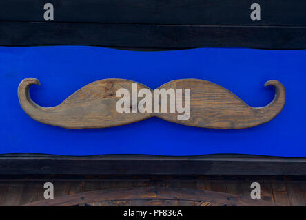 a wooden mustache on a blue wood background Stock Photo
