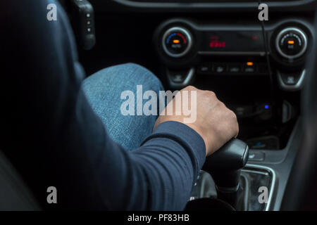Man's hand on car speed shift knob Stock Photo