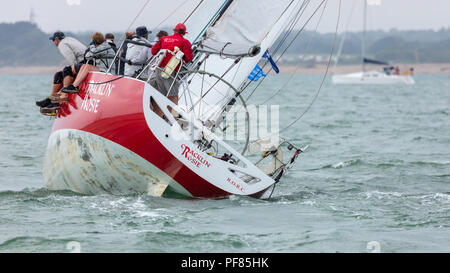 The Solent, Hampshire, UK; 7th August 2018; View To Stern of Yacht Heeled at Extreme Angle Whilst Racing at Cowes Week Regatta. Crew at Side of Boat Stock Photo