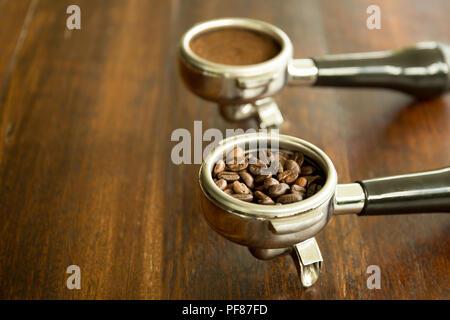 Coffee filter holders for coffee machine with beans and coffee ground on wooden table Stock Photo