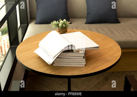 Opened book and plant on wooden table Stock Photo