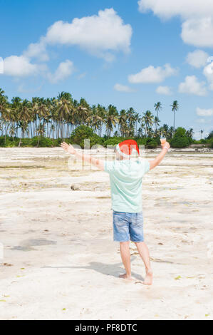 Zanzibar travel festival Santa Claus on the beach drinks beer and smokes a cigar Stock Photo - Alamy