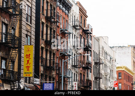 New York City, USA - June 20, 2018: Old buildings with fire escapes in street in Chinatown in Lower Manhattan Stock Photo