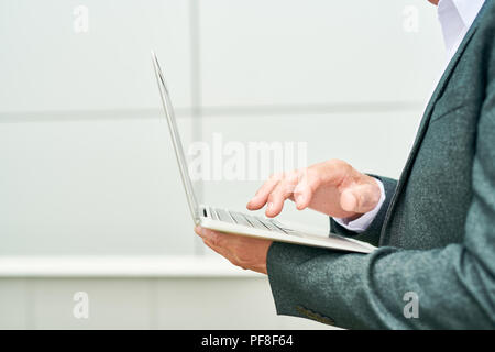 Crop entrepreneur using laptop Stock Photo