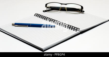 Notebook and glasses and red pen on table. White background Stock Photo
