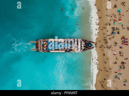 Aerial view of the tourist boat anchoring on the Egremni beach with turquoise colored sea water. Stock Photo