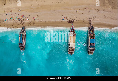 Aerial view of three tourist boats anchoring on the egremni beach with turquoise colored sea water. Stock Photo