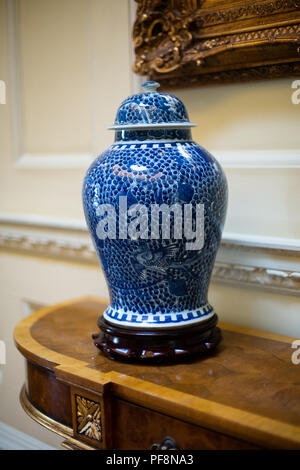 Closeup of chinese blue and white decorative urn on an antique walnut sideboard Stock Photo