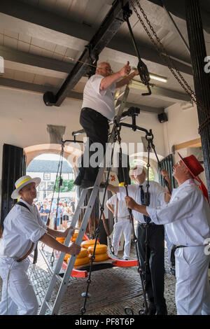 Alkmaar, Netherlands - July 20, 2018: Group of cheese carriers fixing the cheese scale in the Waag building Stock Photo