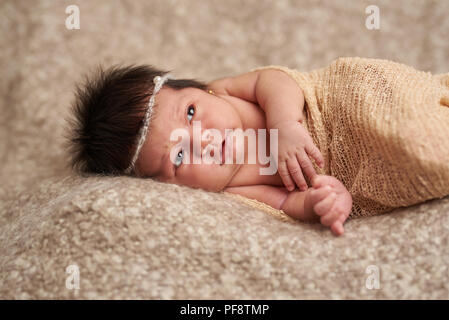 Newborn baby looking worry on brown soft background Stock Photo