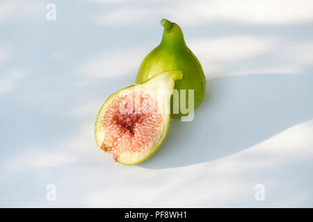 Freshly picked, ripe, organic Kadota figs with pink red pulp, artistic food still life isolated on white background Stock Photo