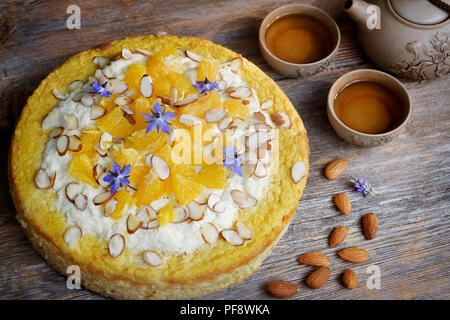 Healthy home-made flourless, sugar-free vegan fruit cake made of almond flour, oranges and coconut oil, artistic food still life on rustic wooden tabl Stock Photo