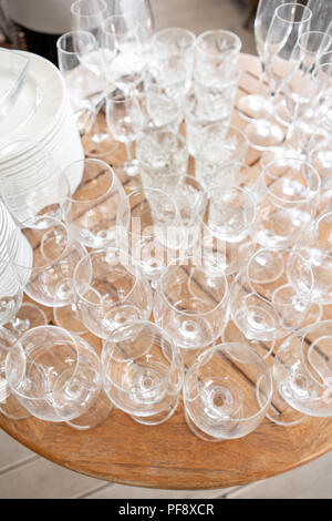Clean plates, glasses and cutlery on wooden table. Catering set-up ready for the event to begin. ervice area the waiter in restaurant. Stock Photo