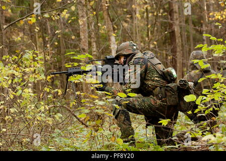 October 2009. Moscow Region, Russia - an airsoft player wearing german camouflage flecktarn aims at an enemy with G36 assault rifle replica during a g Stock Photo