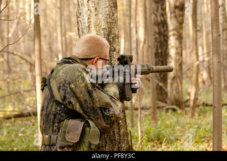 October 2009. Moscow Region, Russia - an airsoft player aims at an enemy with assault rifle replica during a game Stock Photo