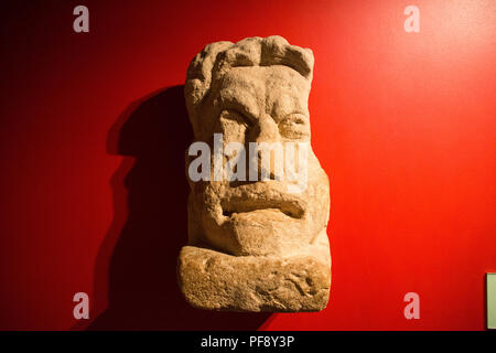 A Roman theatrical mask on display at the Roman Baths in Bath, Somerset, England. Stock Photo