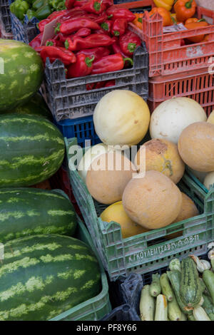 large selection or assortment of fresh fruits and vegetables with colourful green and red chillies on a market stall in the greek town of kerkyra. Stock Photo