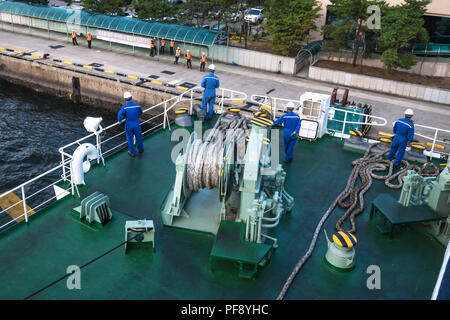 Docking with the ferry from Jeju at Mokpo harbor with orange and blue clothed workers, Mokpo, South Korea Stock Photo