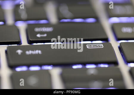 close up of the pause key button symbol special character on an illuminated keyboard on a laptop or computer. Stock Photo