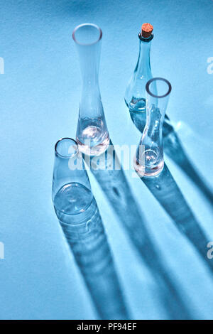 Glass vases empty with shadows and reflection on the surface on a blue background. Stock Photo