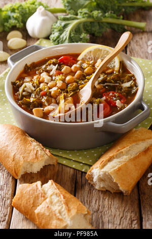 stew of chickpeas, kale, tomatoes, garlic and potatoes with parmesan cheese close-up in a bowl on the table. vertical Stock Photo