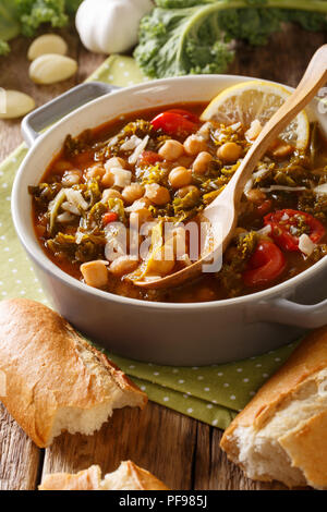 Stewed kale cabbage with chickpeas and vegetables close-up on the table. vertical Stock Photo
