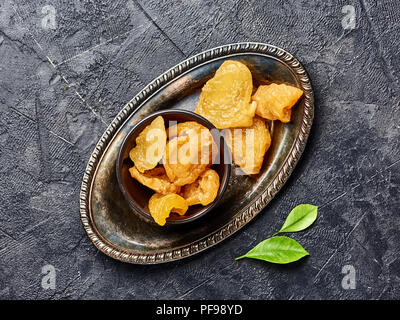 Dried pear, apricot or peach on black background. Top view of candied fruits. Stock Photo