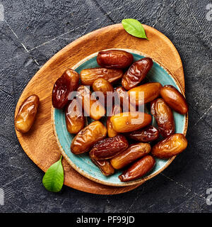 Dried dates fruits on plate. Top view of pitted dates. Stock Photo
