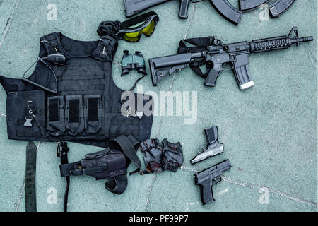 Weapons on the ground. Rifles pistols guns body armor Stock Photo