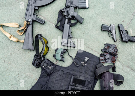 Weapons on the ground. Rifles pistols guns body armor Stock Photo