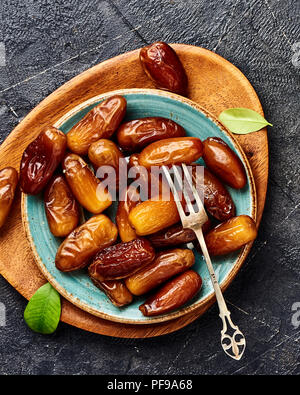 Dried dates fruits on plate. Top view of pitted dates. Stock Photo