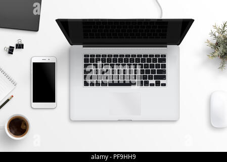 Laptop and smart phone on office desk. Blank screen for mockup, app or responsive web site design presentation. Flat lay. Stock Photo