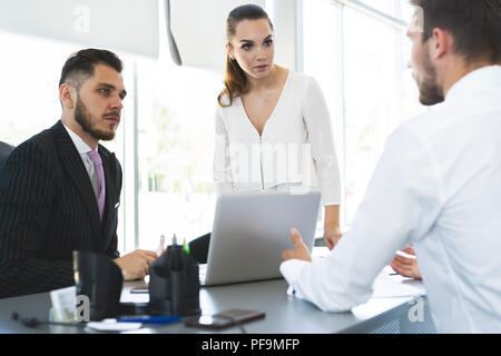 Professional group of managers collaborating on creative budget report using laptop computers, concentrated team of experts searching information in n Stock Photo