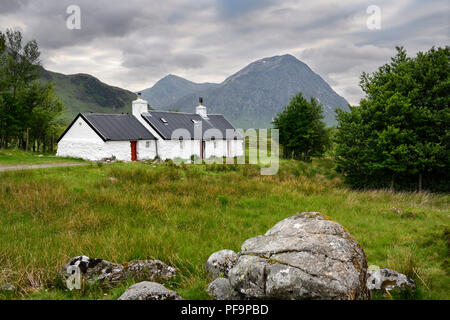 White washed stone Black Rock Cottage climbing hut in Glen Coe with Stob Dhearg of Buachaille Etive Mor mountain range Scottish Highlands Scotland UK Stock Photo