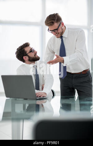two employees discuss business issues near the office Desk Stock Photo