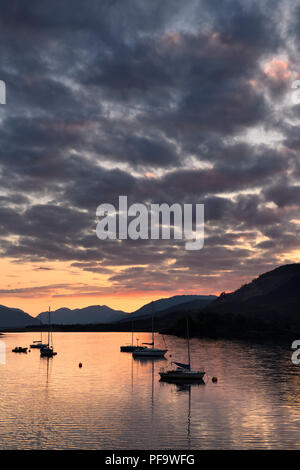 Red Sunset with clouds on Loch Leven with moored sailboats at Glencoe Boat Club Scottish Highlands Scotland UK Stock Photo