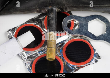 Bicycle tube, glue and patches in the workshop. Repairing a damaged wheel in a bike. Light background. Stock Photo