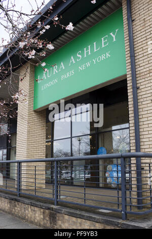 Milton Keynes, UK - March 29, 2018. Trees blossom outside a Laura Ashley store. Shares in Laura Ashley have fallen by almost 90% since 2015. Stock Photo