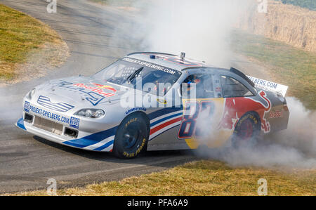 2007 Red Bull Toyota Camry NASCAR winner with driver Patrick Friesacher smoking the raer tyres at the 2018 Goodwood Festival of Speed, Sussex, UK. Stock Photo