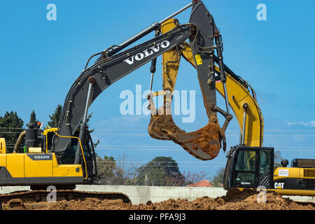 Two yellow excavators working on a road construction site with road ...