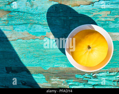 Fresh yellow melon isolated on the old blue wooden table colorful abstract summer background Stock Photo