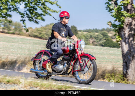 A man on a motorbike, Jawa 250, Czech Republic old man in a retro from 50s on a rural road active senior man Stock Photo