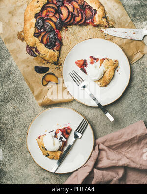 Flat-lay of plum galetta sweet cake pieces in white plates Stock Photo