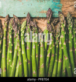 Raw uncooked green asparagus over rustic wooden tray background, square crop Stock Photo