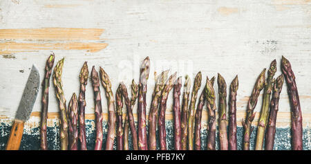 Fresh Raw purple asparagus over rustic wooden background, copy space Stock Photo