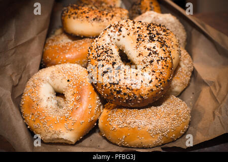 Variety of assorted authentic New York style Bagels with seeds in a brown paper bag. Stock Photo