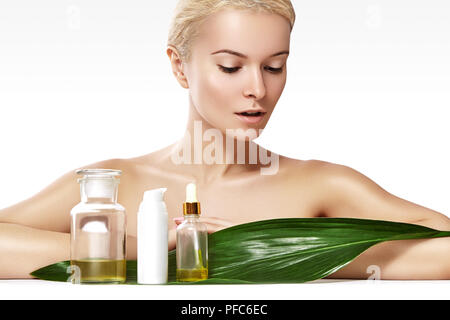 Beautiful woman applies Organic Cosmetic and oils for Beauty. Spa and Wellness. Model with Clean Skin, shiny hair. Healthcare. Stock Photo