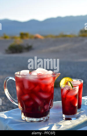 red colorful hibiscus flower iced tea cold drink in glasses and pitcher Stock Photo