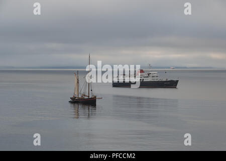 Mousehole, Cornwall, UK. 21st Aug, 2018. UK Weather. It was a misty start to the day at Mousehole, with a lugger and the cruiser 'Hebridean Princess' anchored in Mounts Bay Credit: Simon Maycock/Alamy Live News Stock Photo