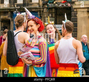 Edinburgh Fringe, Edinburgh, Scotland, UK. 21st August 2018. Fringe goers and festival performers throng the Virgin Money sponsored street venue on the Royal Mile in the last week of the fringe festival. Fringe performers in colourful costumes from a show called Broken Romantics had out flyers to people passing by Stock Photo